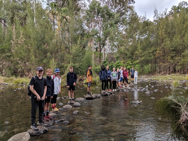 group of students standing on rivers edge
