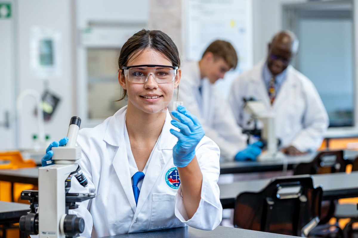 female student with microscope in a science lab
